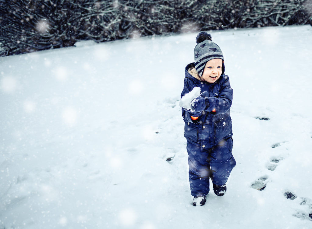 little boy playing in the snow