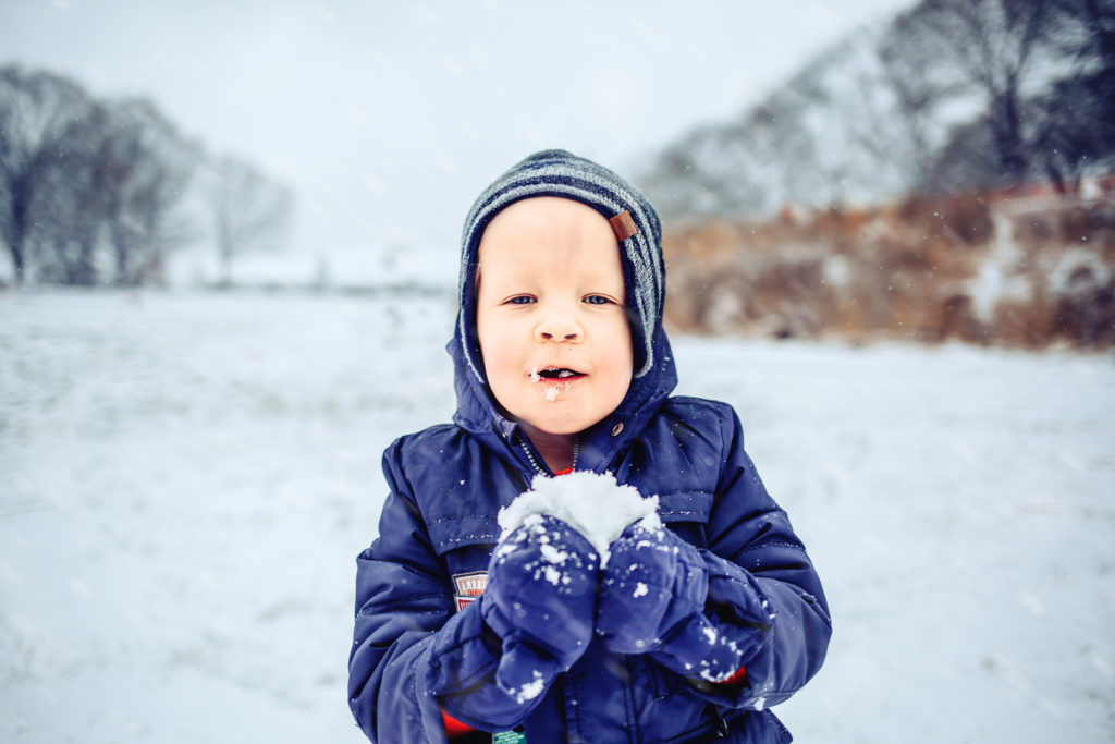 little boy eating the snow