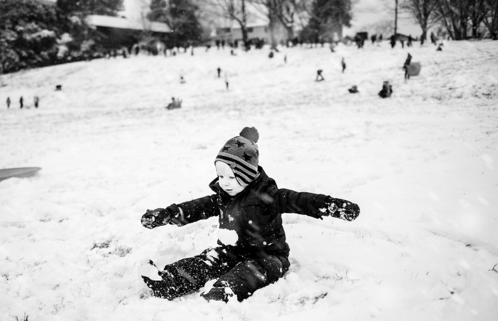 little boy sitting in the snow