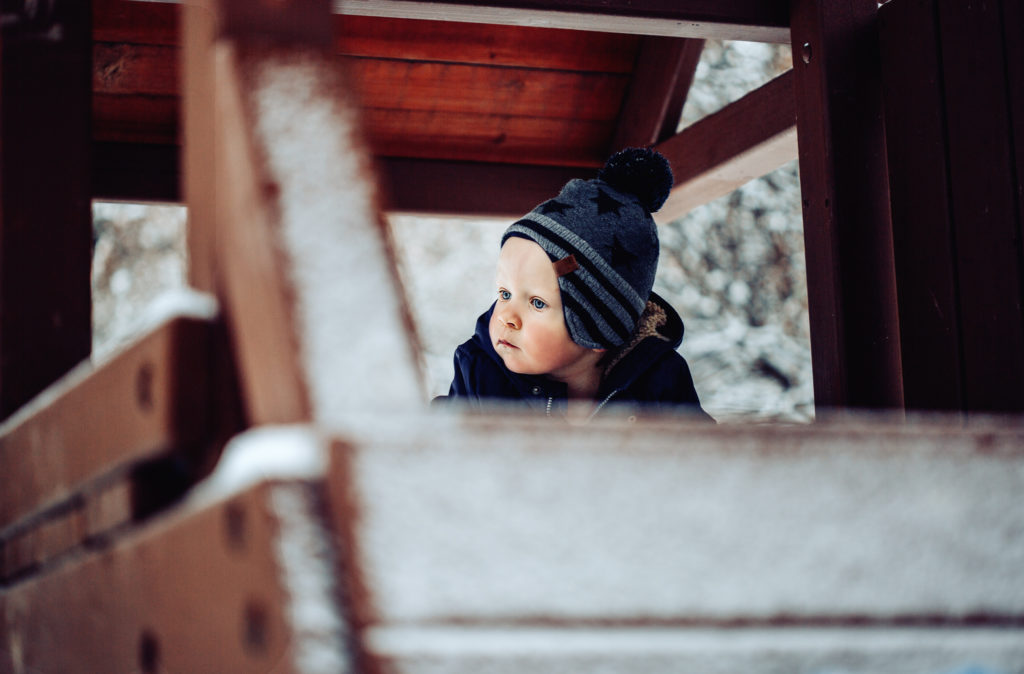little boy in treehouse in the snow