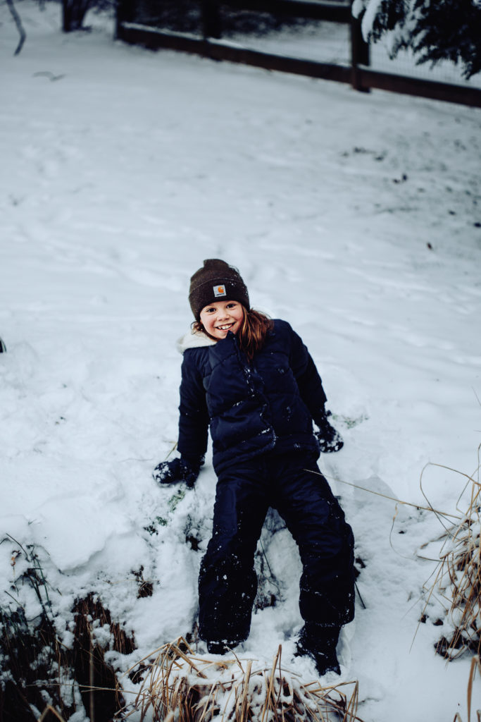 little girl laying in the snow