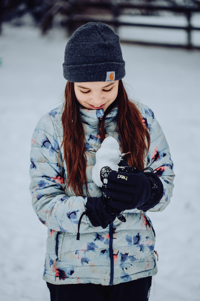 girl holding small snowman